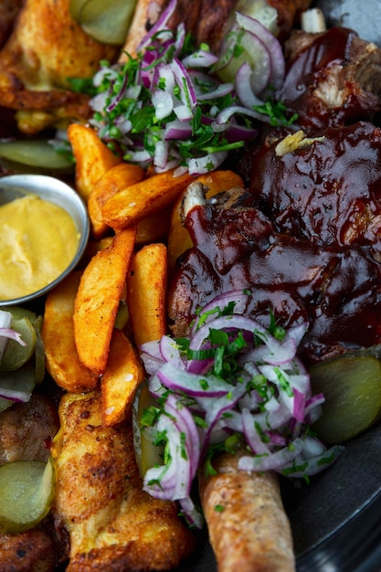 Viande barbecue avec pommes de terre et sauce sur une assiette Gros plan Vue de dessus Verticale