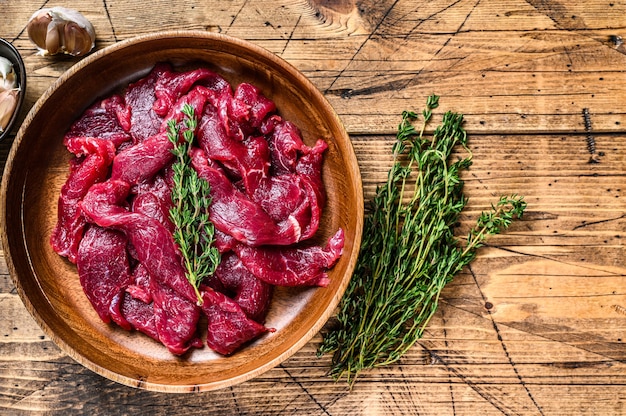 Viande de boeuf crue crue tranchée en lanières avec des herbes fraîches pour boeuf stroganoff