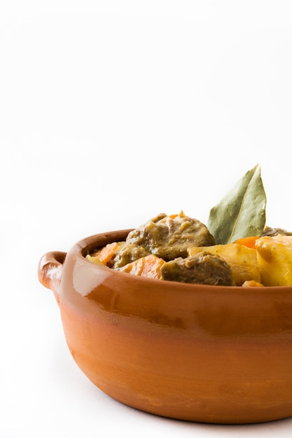 Viande de boeuf cuite avec pommes de terre, carottes et épices dans un bol isolé sur fond blanc