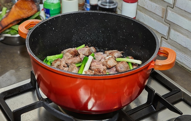 La viande de bœuf en dés est cuite avec des oignons dans une marmite sur une cuisinière à gaz