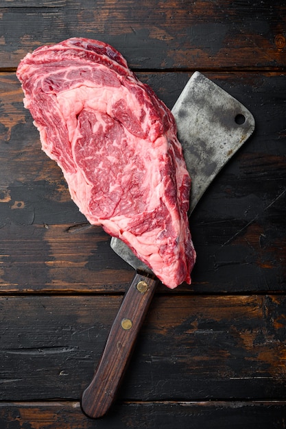 Viande de bœuf de faux-filet coupé cru, avec un vieux couteau couperet de boucher