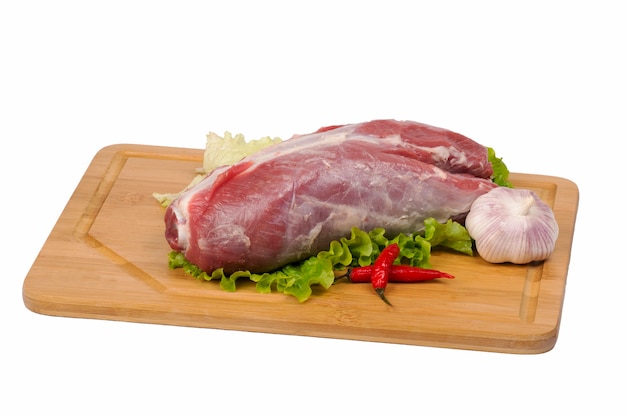 Viande de boeuf fraîche et crue sur une planche à découper sur fond blanc.