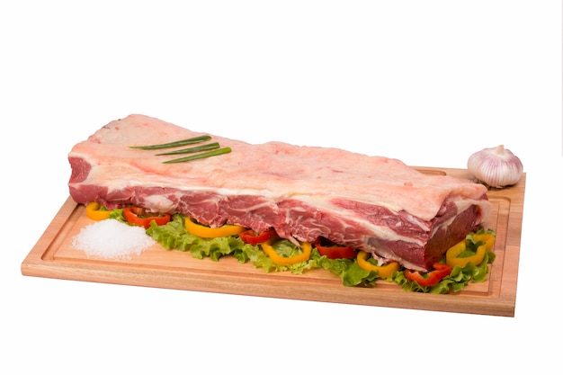 Viande de boeuf fraîche et crue sur une planche à découper sur fond blanc.