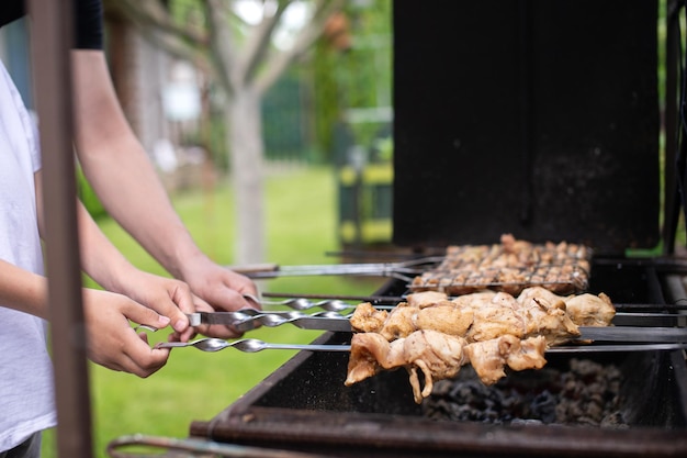 La viande sur des brochettes est frite sur le gril