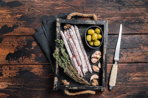 Viande Charcuterie Fuet salami saucisses aux olives et herbes Fond bois Vue de dessus