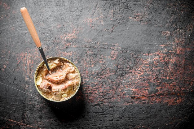 Viande en conserve dans une boîte avec une cuillère