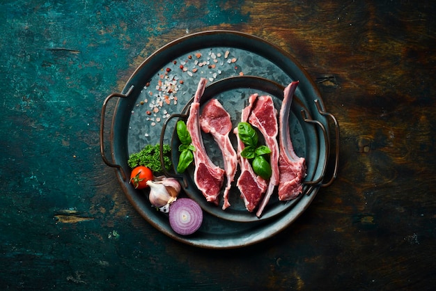 Viande Côtes d'agneau crues sur un plateau en métal préparation pour la cuisson Style rustique Photo pour le catalogue