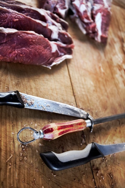 Viande et couteaux sur un plan en bois