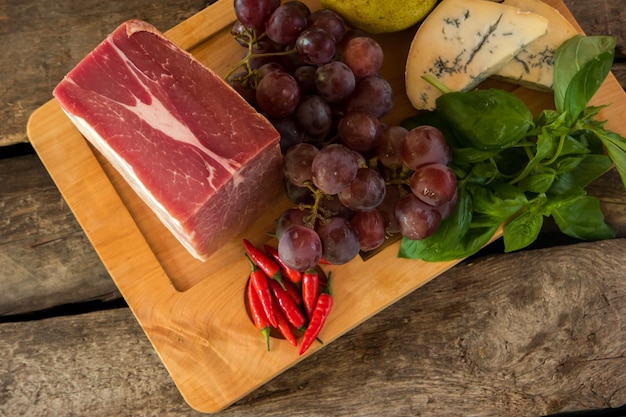 Viande crue allongée à bord. Piments et raisins. Tous les ingrédients sont naturels. Nourriture fraîche et propre.