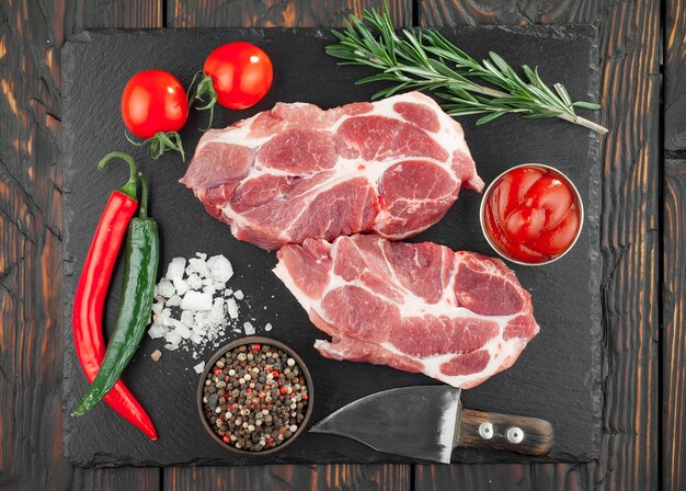 Viande crue aux épices dans une composition avec accessoires de cuisine