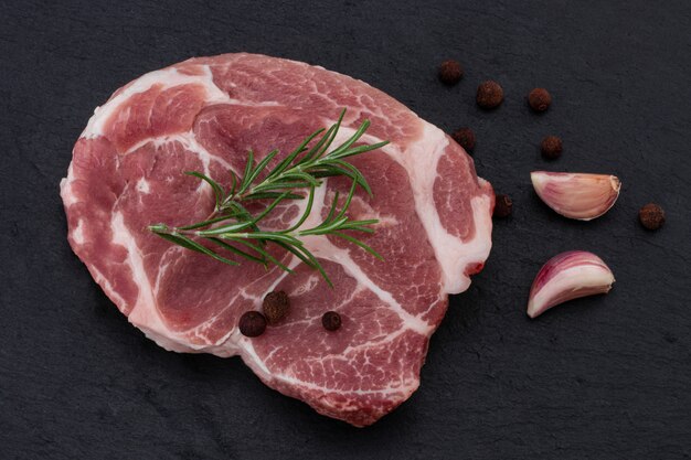 Viande crue aux épices sur fond noir