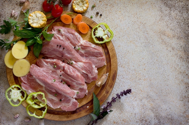 Viande crue aux légumes sur une planche à découper