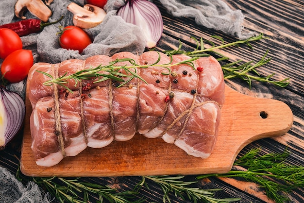 Viande crue Filet de boeuf aux légumes frais et romarin et épices sur un fond en bois noir Vue de dessus Espace libre pour le texte