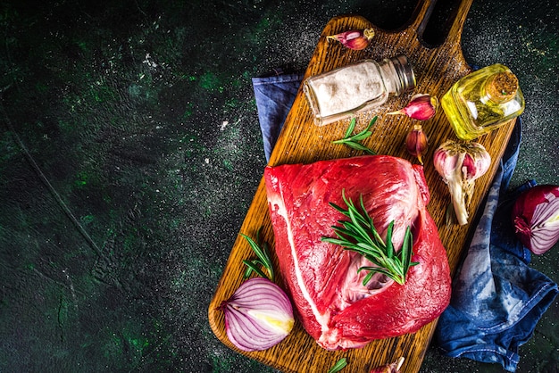 Viande crue, filet de boeuf, gros morceau sur une planche à découper avec des épices pour la cuisson.