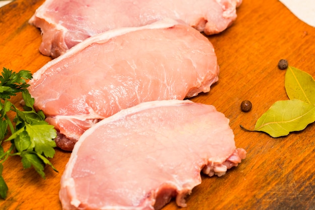 Viande crue fraîche aux épices sur fond de bois