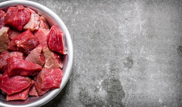 Viande crue hachée dans une tasse sur la table en pierre