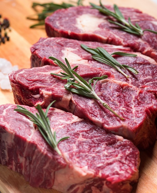 Viande crue avec herbes et épices sur le plateau.