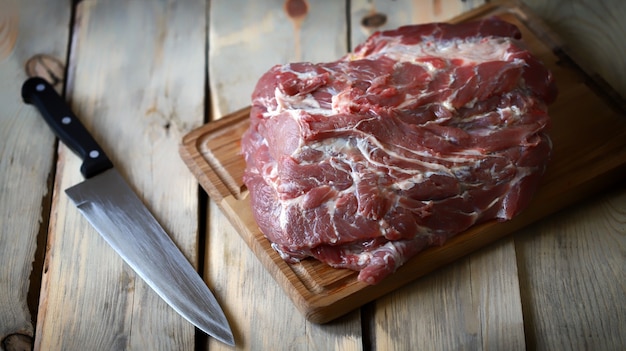 Viande crue sur une planche et un couteau