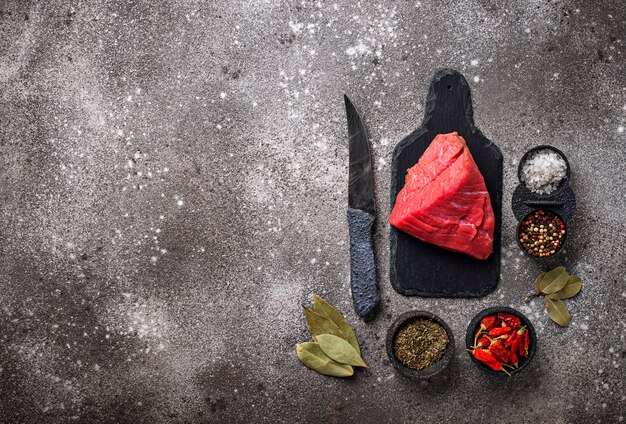 Viande crue sur une planche à découper avec des épices