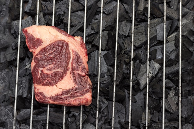 Viande crue. Steak de boeuf marbré sur le gril.