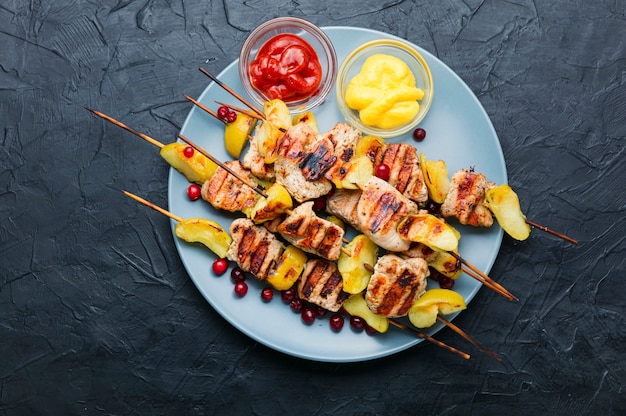 Viande de dinde frite avec pomme sur des brochettes en bois. Barbecue appétissant.