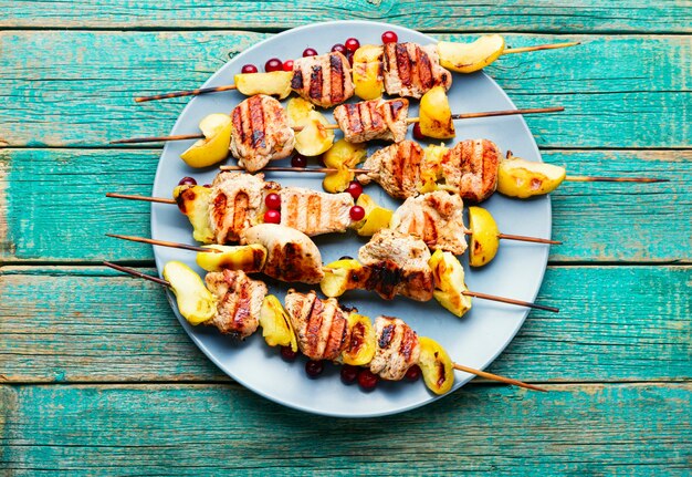 Viande de dinde frite avec pomme sur des brochettes en bois. Barbecue appétissant.