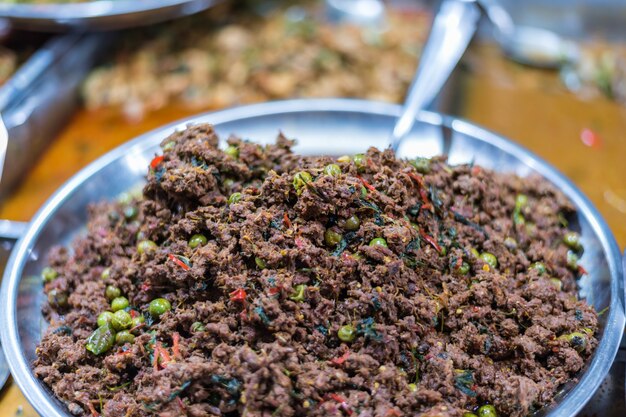 Viande épicée chaude frite avec chili thaï et herbe en vente au marché thaïlandais ou au resta