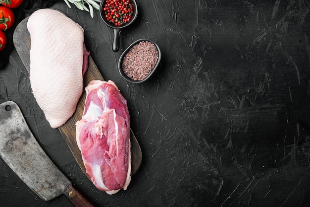 Viande de filet crue de magret de canard avec un vieux couteau de couperet de boucher sur fond de pierre noire