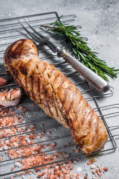 Viande de filet de filet de porc grillé sur le gril. Fond gris. Vue de dessus.