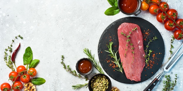 Viande de filet fraîche et crue Pièce entière de steaks de filet de boeuf sertie d'épices et d'herbes Viande Sur un fond de pierre