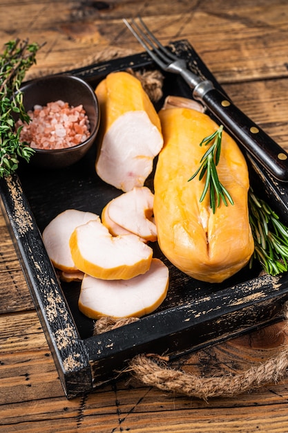 Viande de filet de poitrine de poulet fumé à chaud sur une planche de bois aux herbes