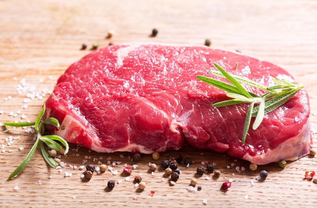 Viande fraîche au romarin sur planche de bois