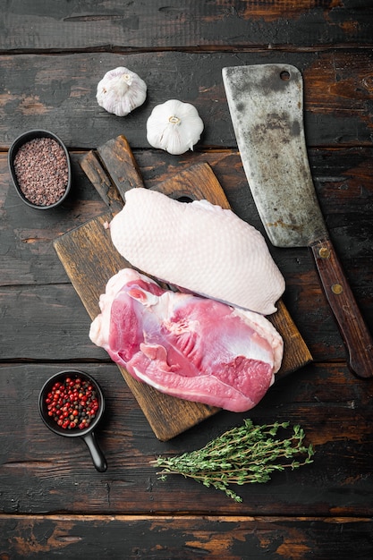 Viande fraîche crue, filet de magret de canard, avec des herbes et des ingrédients, sur une planche à découper en bois