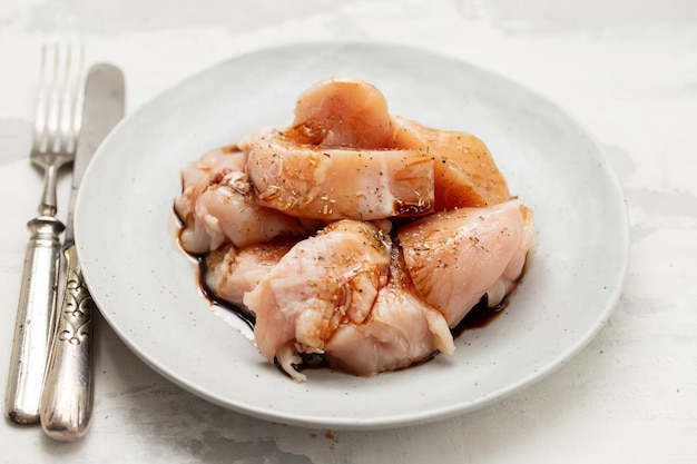 Viande fraîche crue avec sauce et épices sur plat gris