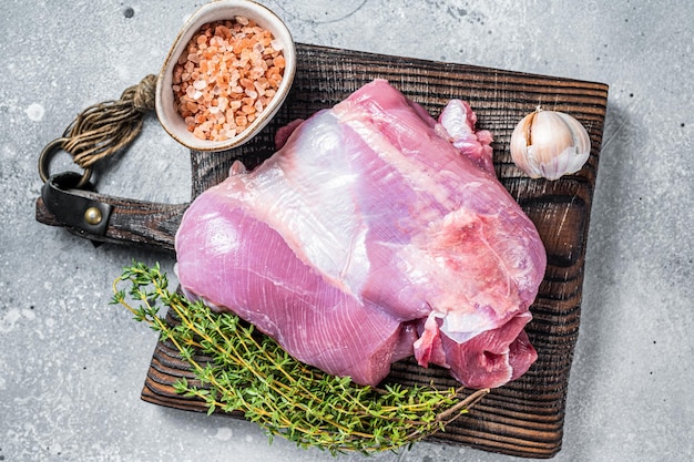 Viande fraîche de volaille Filet de cuisse de dinde crue sur une planche à découper en bois Fond gris Vue de dessus