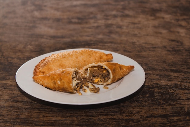 Viande frite d'Amérique latine et empanadas aux œufs sur une table en bois.