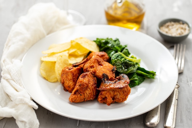 Viande frite avec croustilles et légumes verts sur plaque blanche