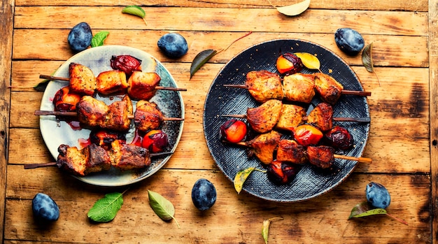 Viande frite grillée sur des brochettes en bois. Brochettes à la sauce aux prunes. Viande barbecue