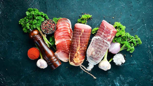 Viande fumée aux épices et herbes Sur un fond en bois noir Vue de dessus Espace libre pour votre texte