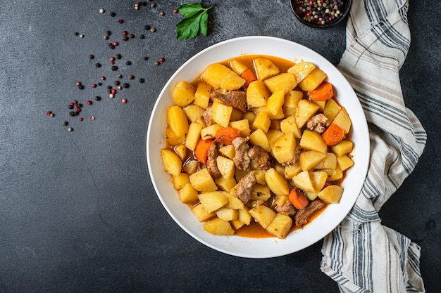 Viande de goulache avec pommes de terre, légumes cuits et porc