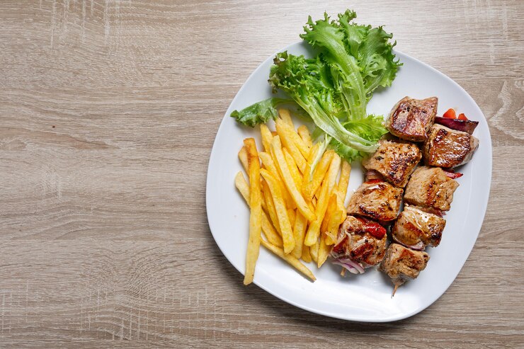 Viande grecque sur brochettes avec salade servie sur assiette