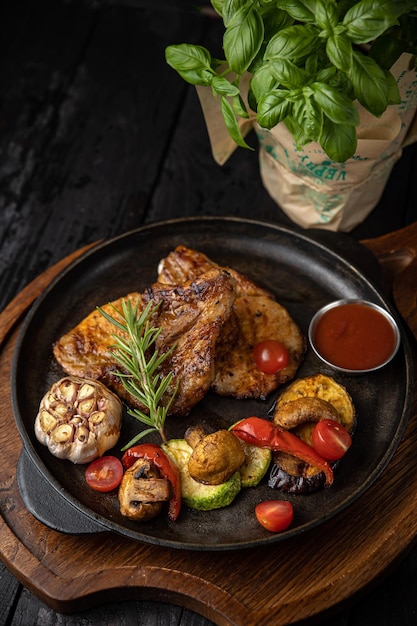 viande grillée avec légumes et épices sur fond noir