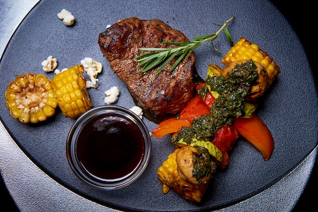 Viande grillée avec des légumes avec de la sauce sur un plat.