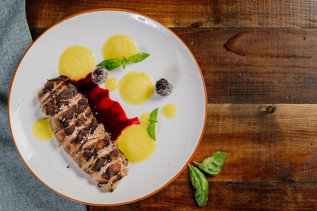 Viande grillée avec sauce aux fruits sur le fond en bois