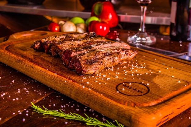 VIANDE GRILLÉE SUR UNE TABLE EN BOIS