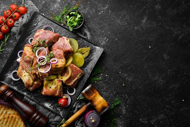 Viande Kebab mariné cru avec oignons et épices sur une plaque noire Vue de dessus Espace de copie gratuit