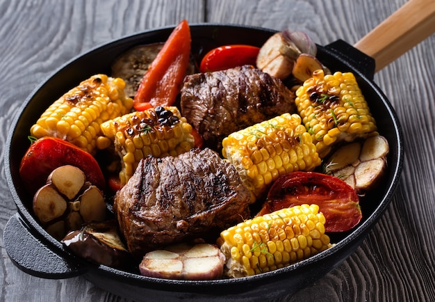 Viande et légumes frits sur une poêle en fonte