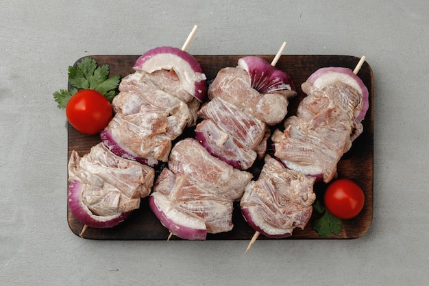 Viande marinée en brochettes à l'oignon sur table grise