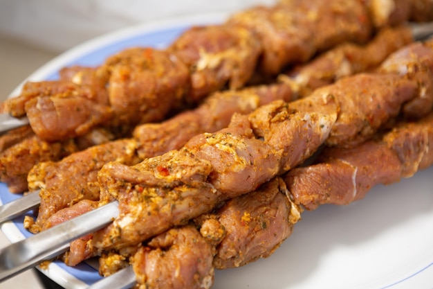 La viande marinée pour kebab sur des brochettes se trouve sur une assiette