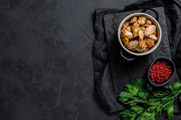 Viande de moule crue sur une planche à découper avec du persil.